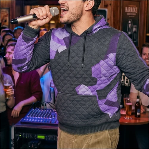 Danny Wave singing into a microphone in a purple and black hoodie.